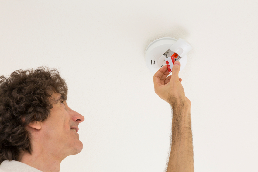 Man Fixing Smoke Alarm