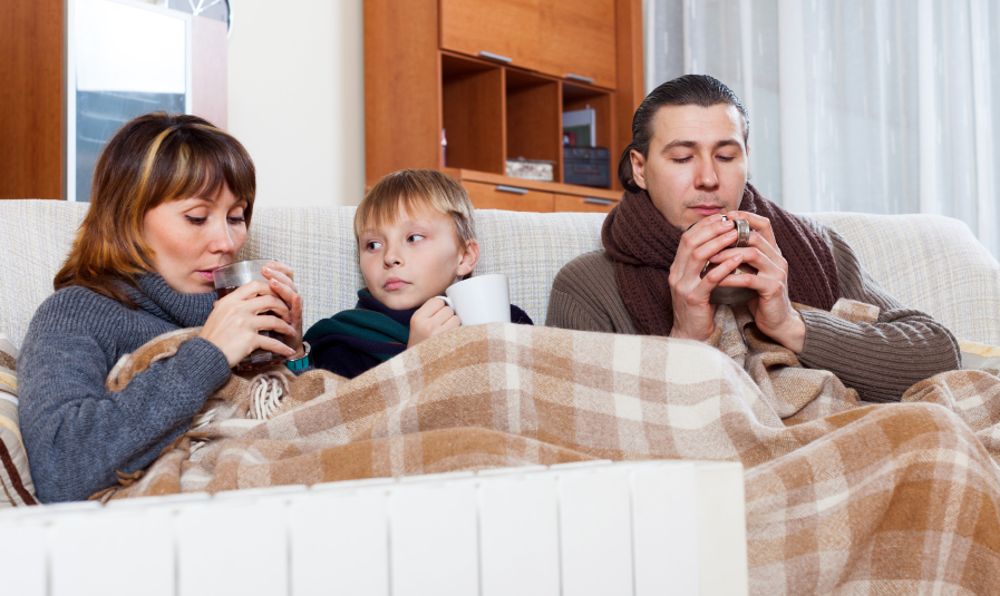 freezing family of three warming near warm radiator